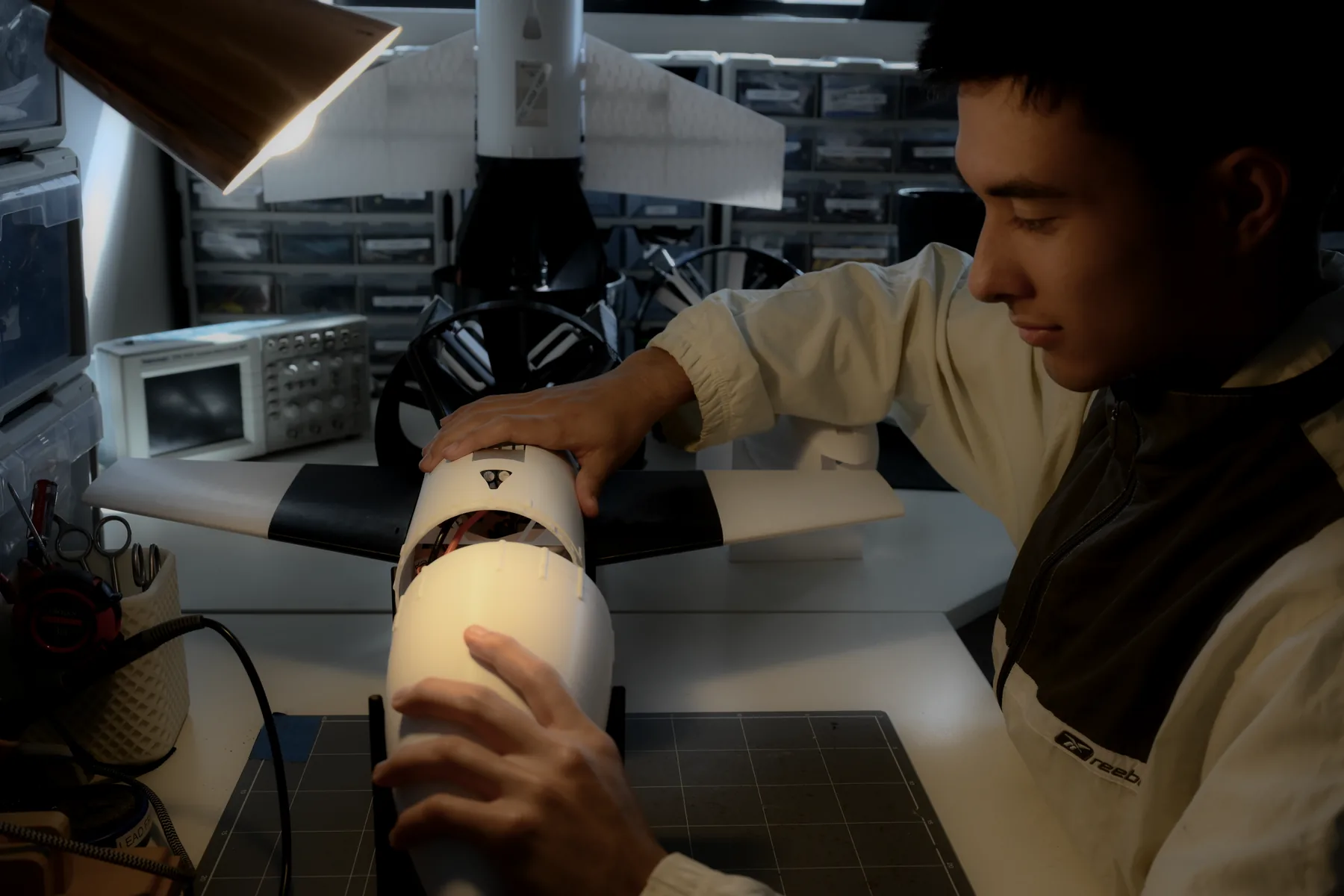 Two people assembling aircraft components at the bench